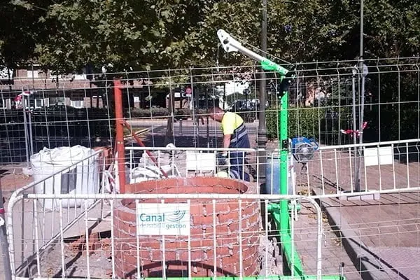 Obra de acometida en vía pública con cartel del Canal de Isabel II